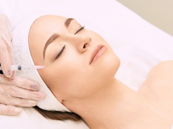 Dermal filler being injected into the mid-face to restore lost volume